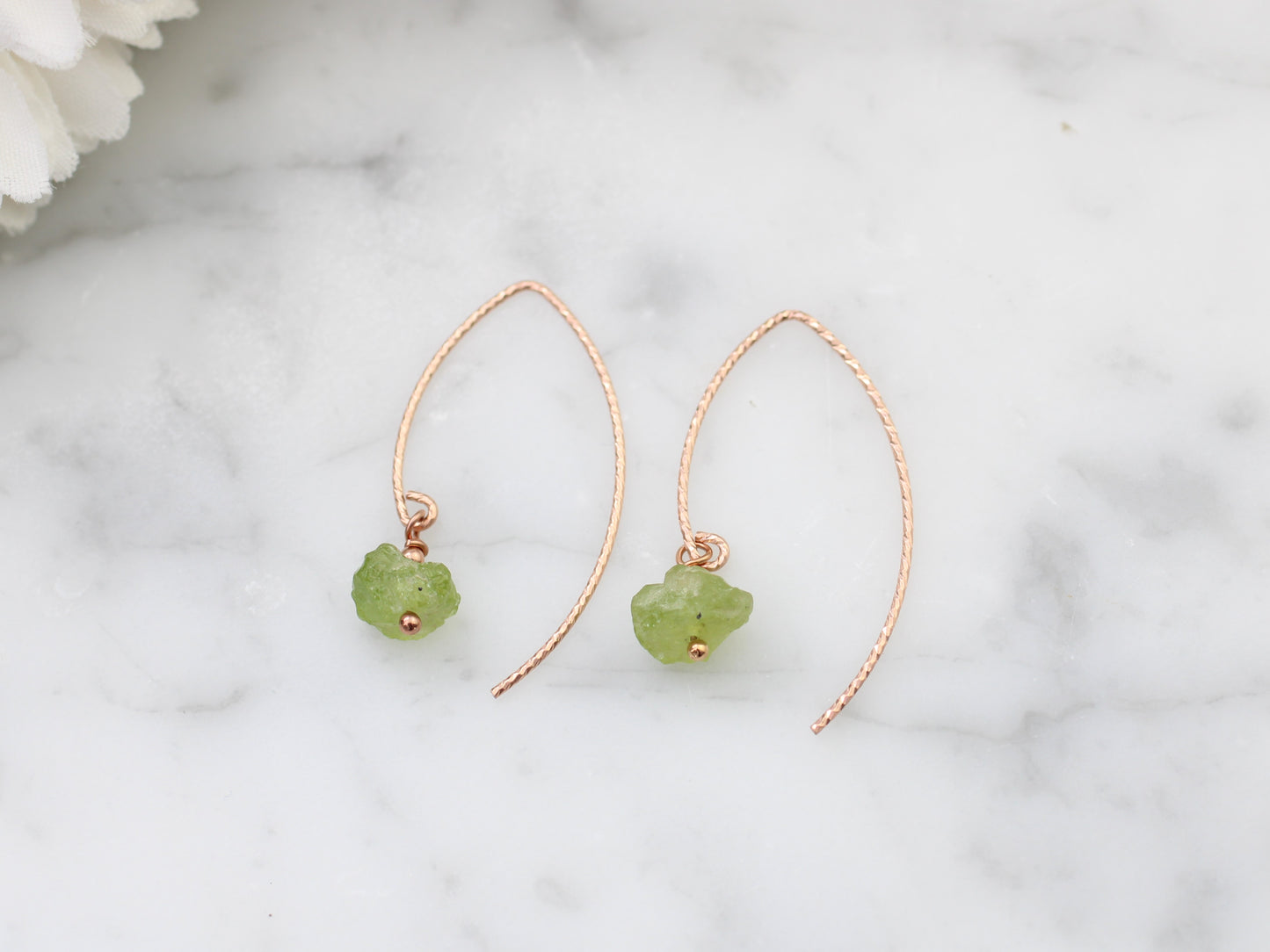 Raw peridot earrings in gold.