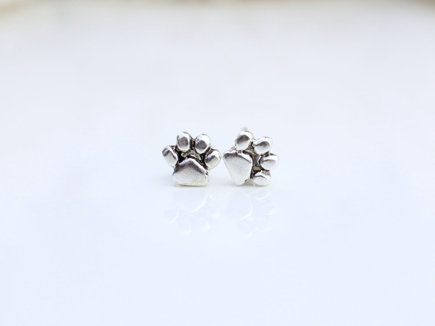 Sterling silver paw print earrings.