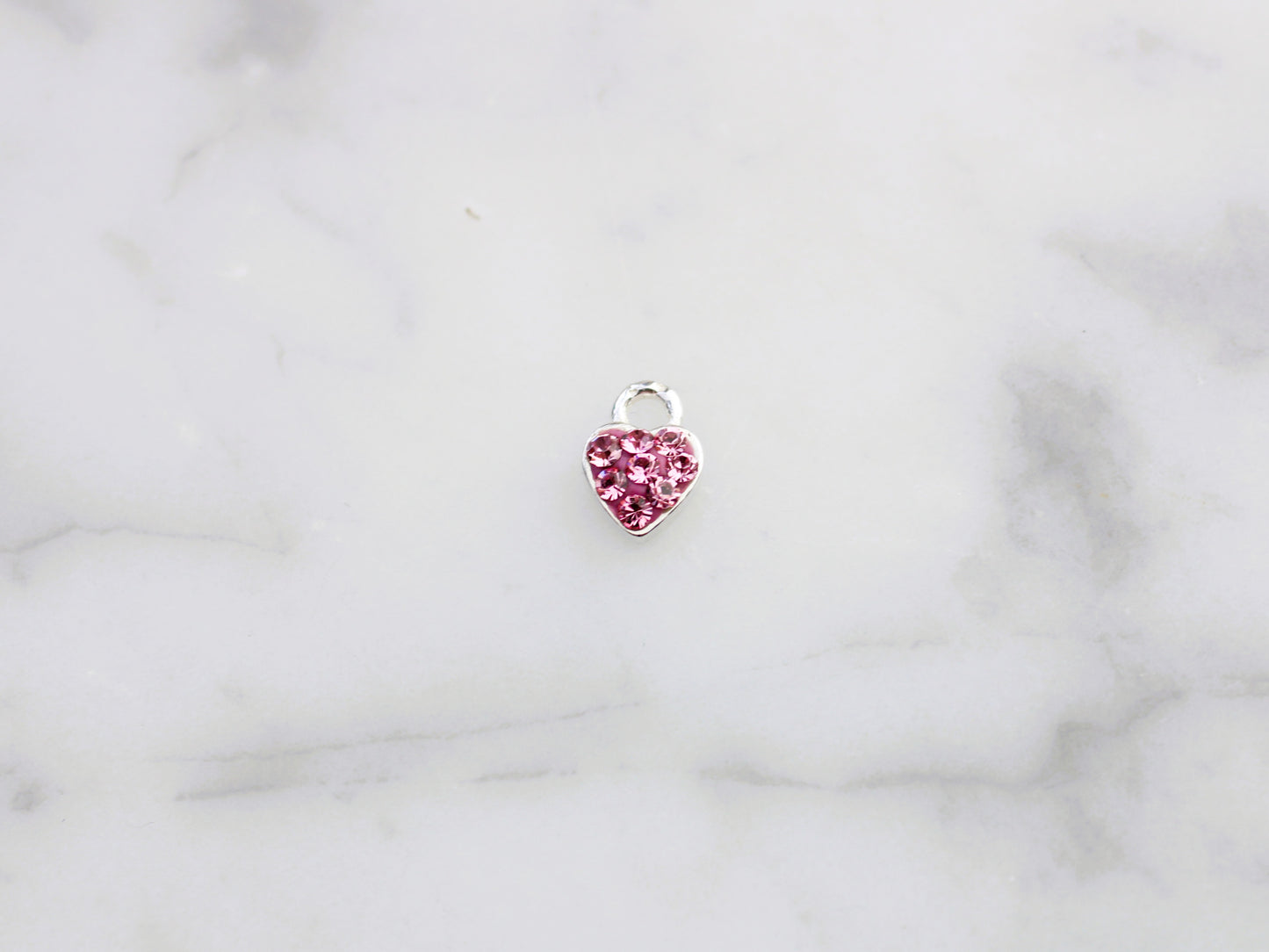 Pink cubic zirconia heart charm.