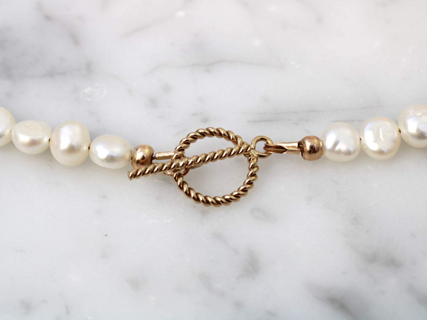 Pearl bracelet with gold clasp.