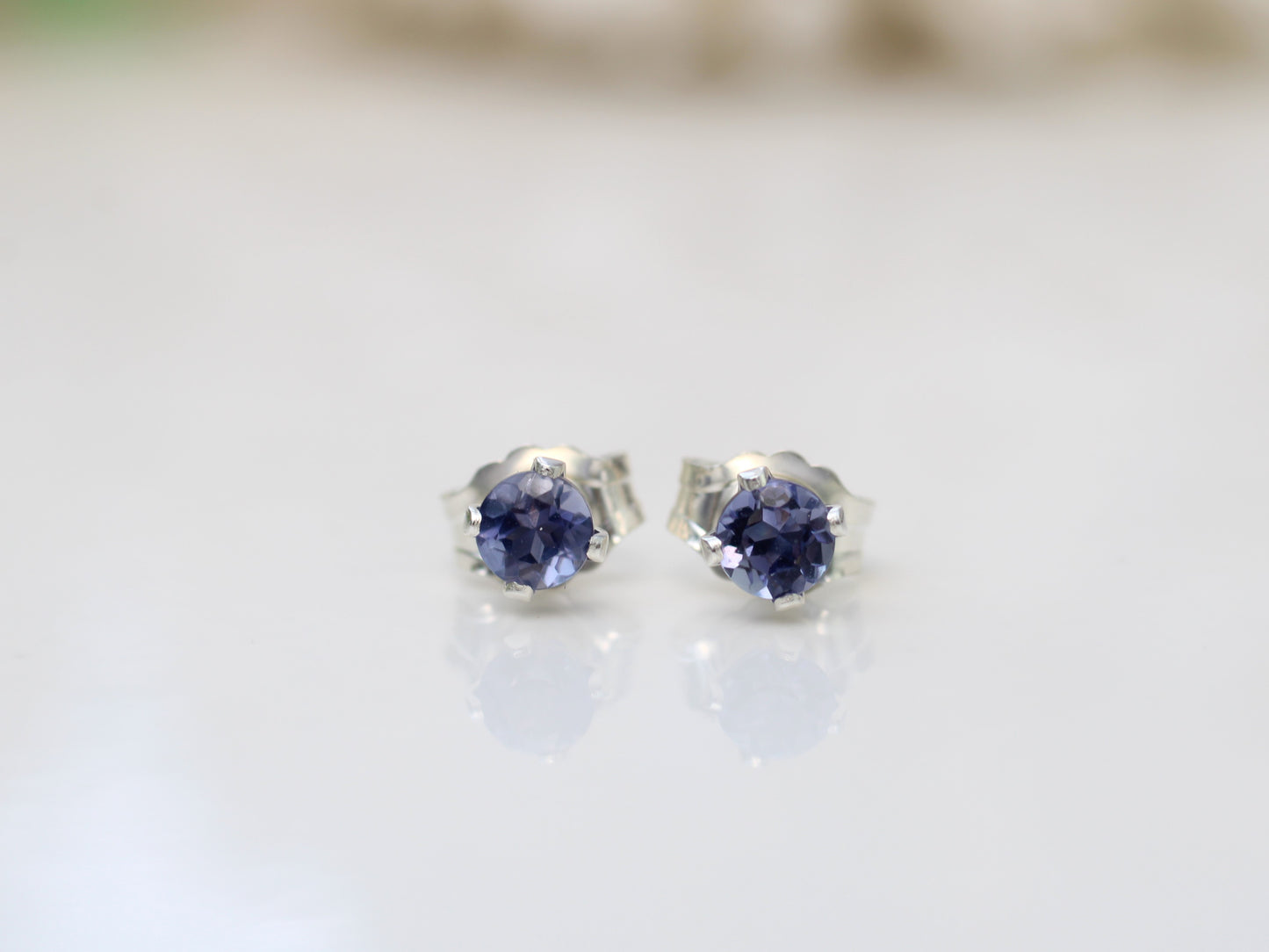 Iolite stud earrings in sterling silver or gold.