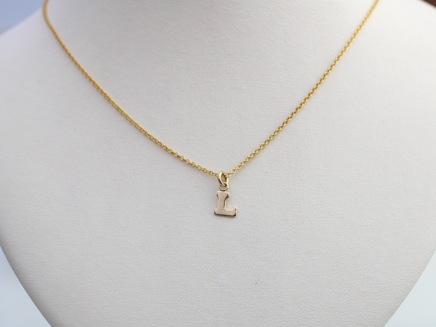 Gold initial necklace.