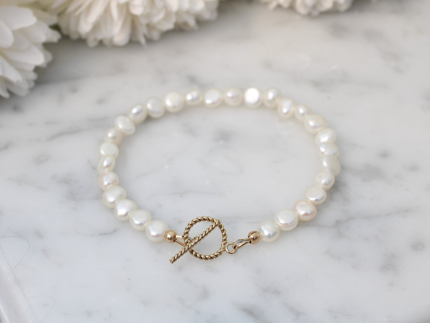 Pearl bracelet with gold clasp.