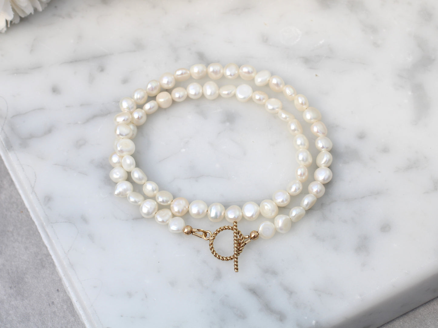 Pearl choker necklace with gold clasp.