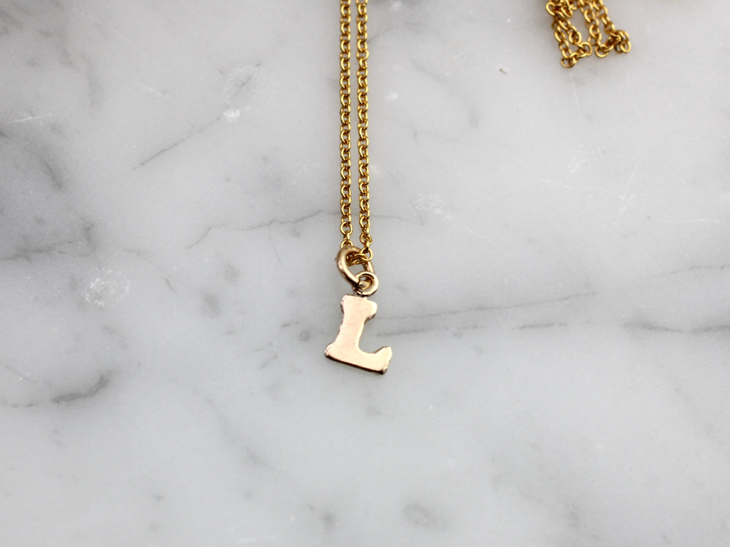 Gold initial necklace.