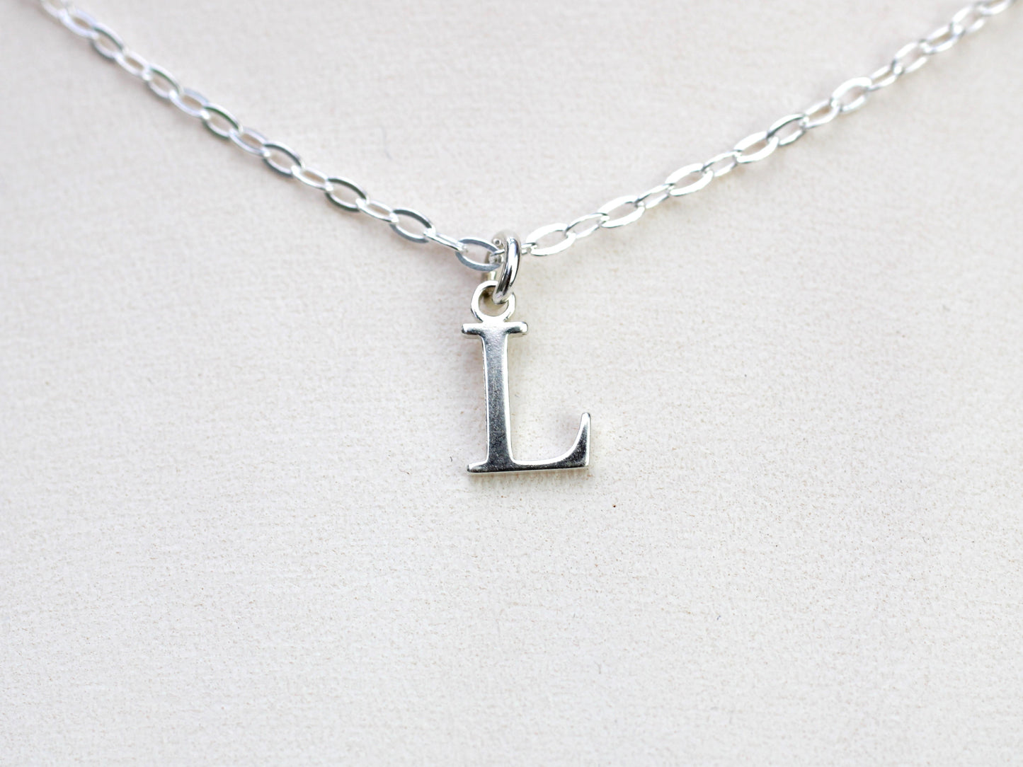 Silver initial necklace.