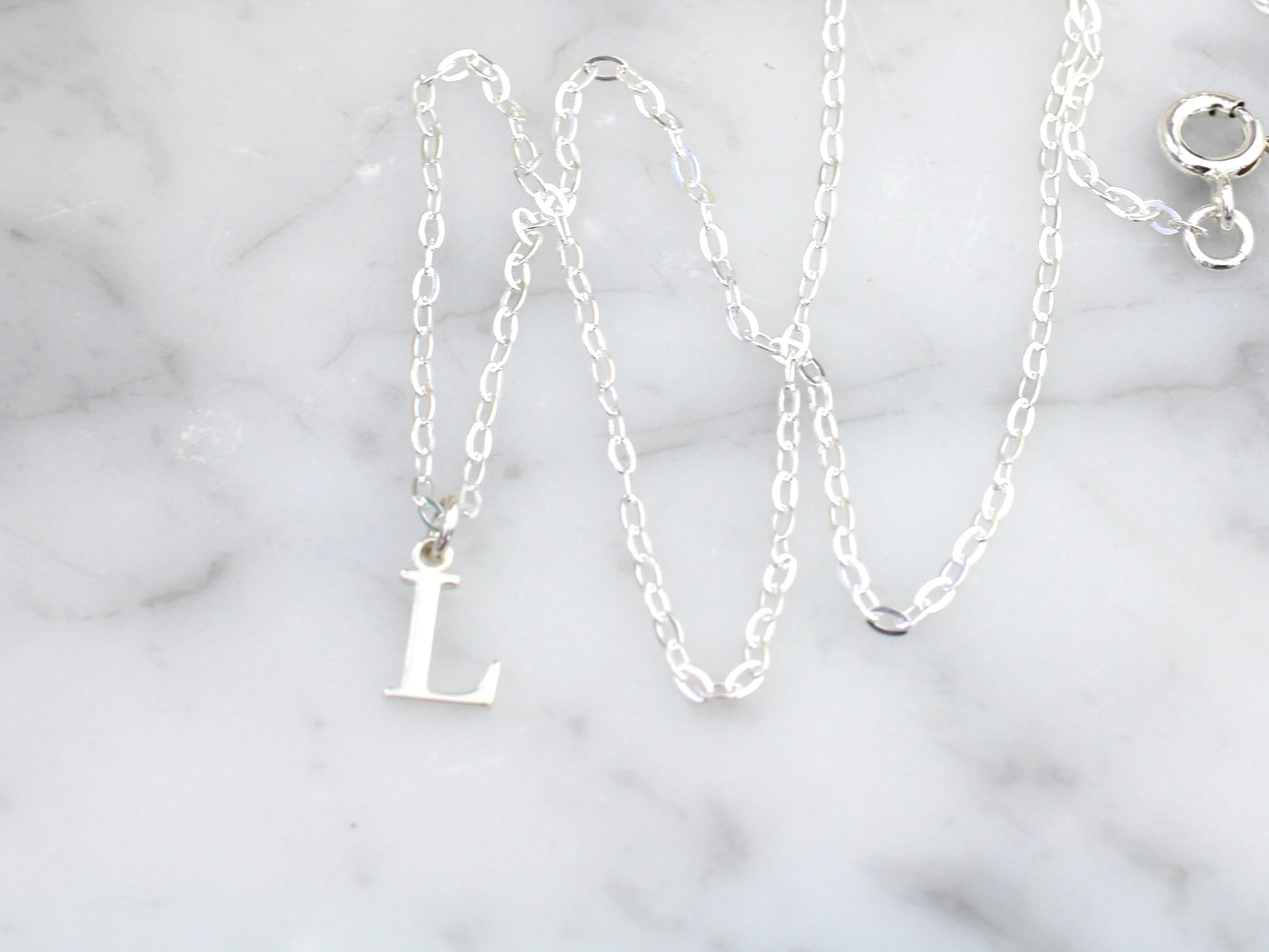 Silver initial necklace.