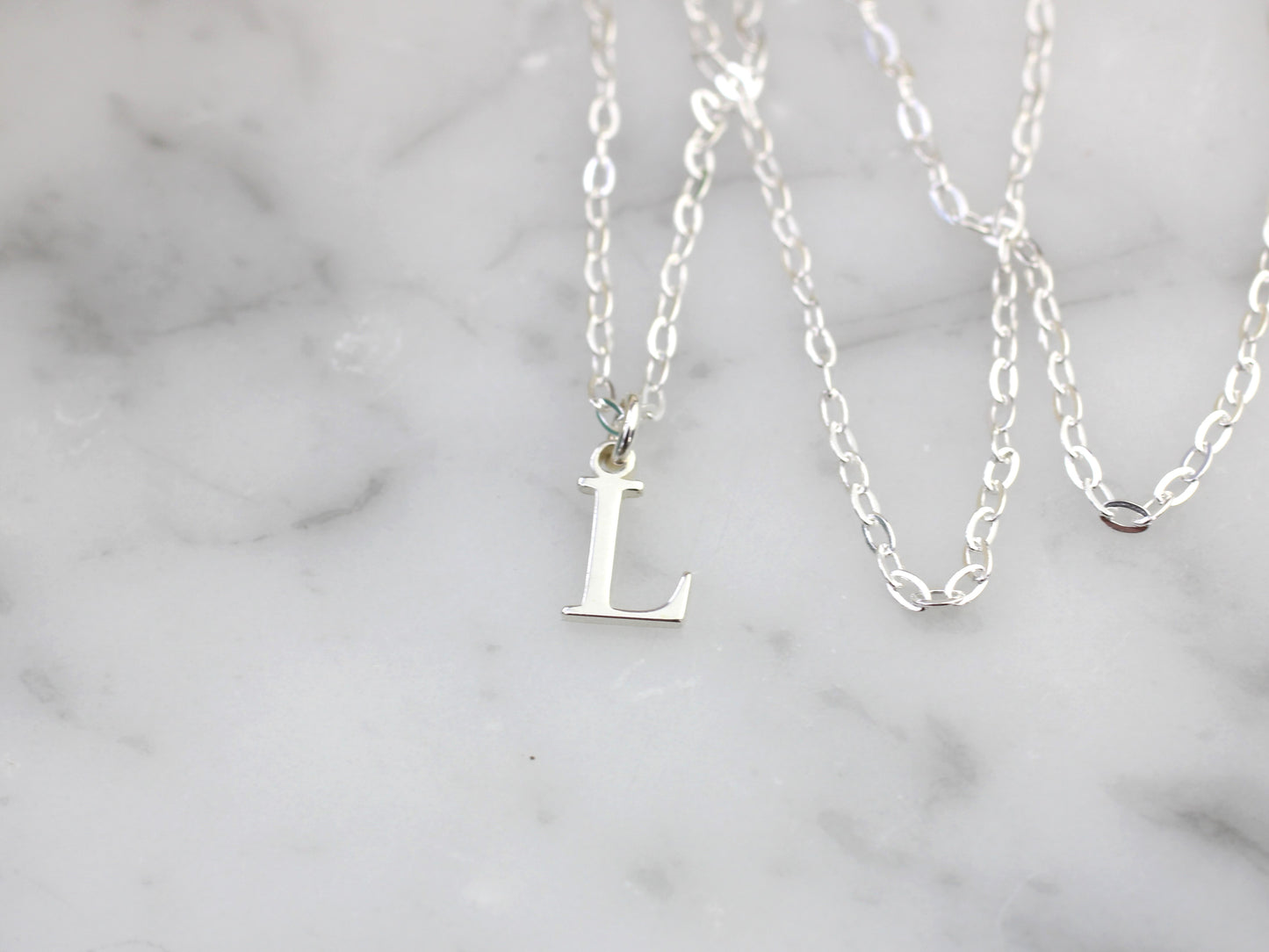 Silver initial necklace.