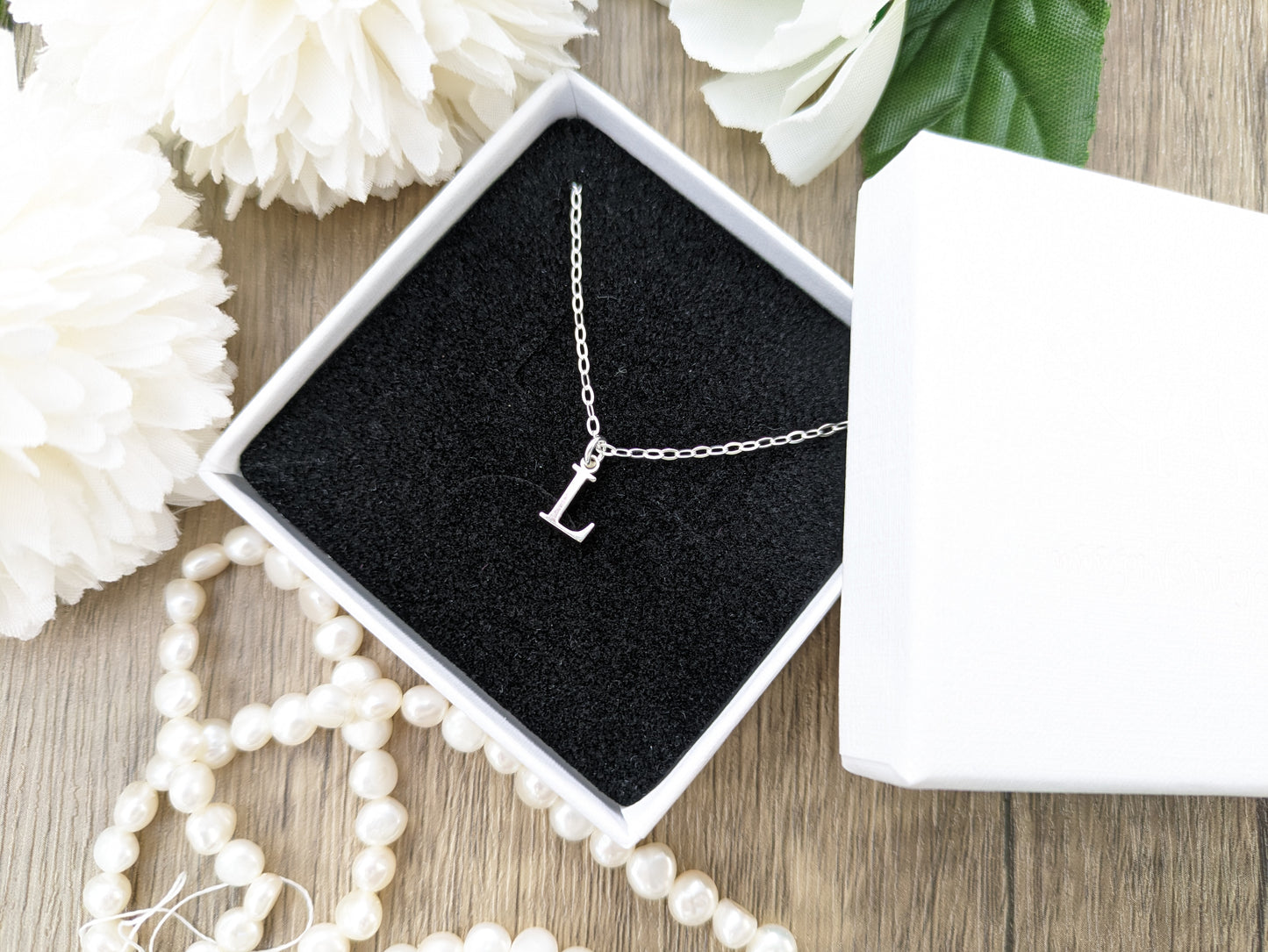 Silver initial necklace.