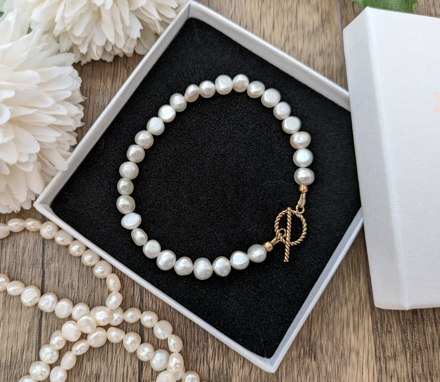 Pearl bracelet with gold clasp.