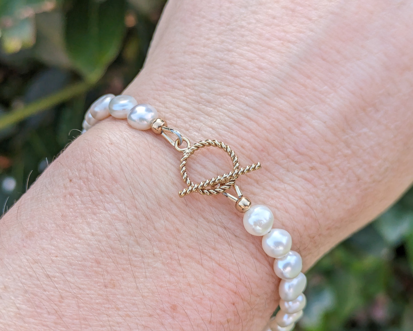 Pearl bracelet with gold clasp.