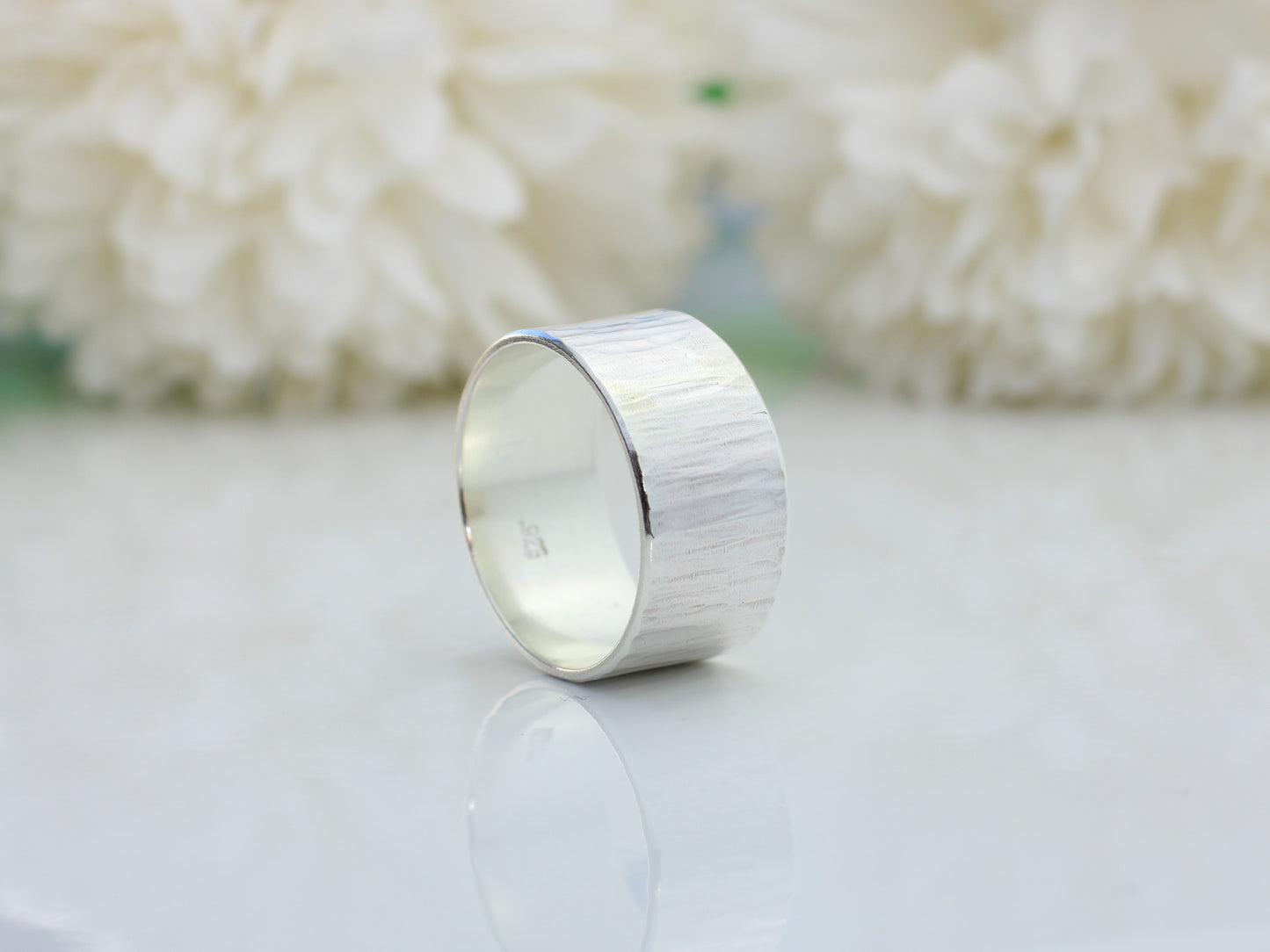 Sterling silver wood grain effect ring made with recycled metal.