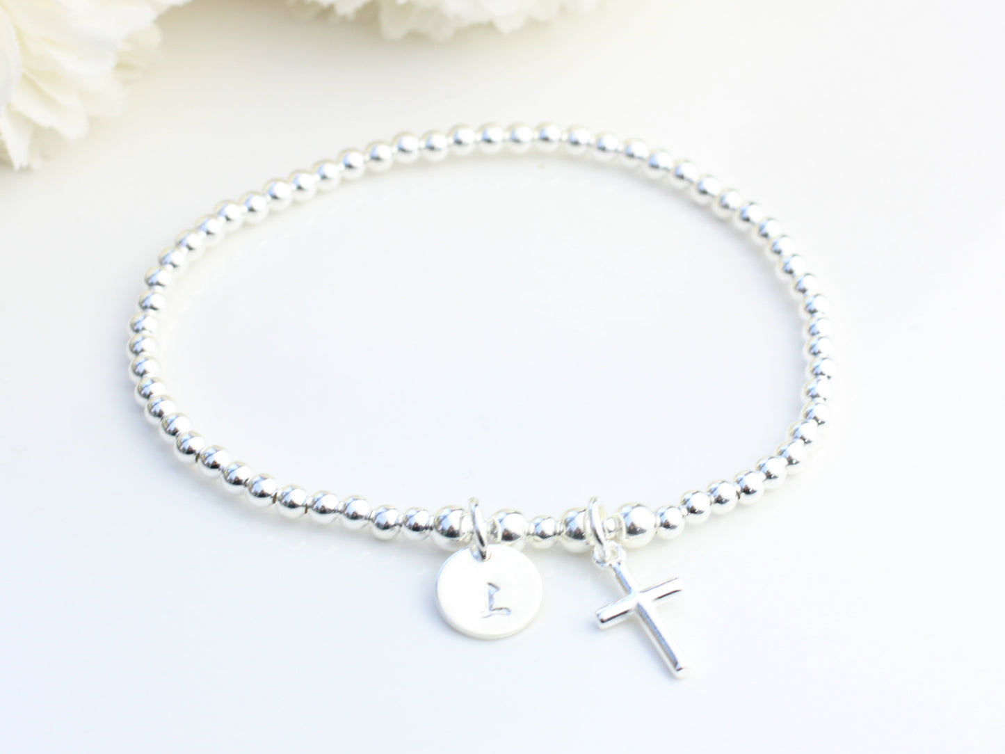 Cross charm bracelet with initial.