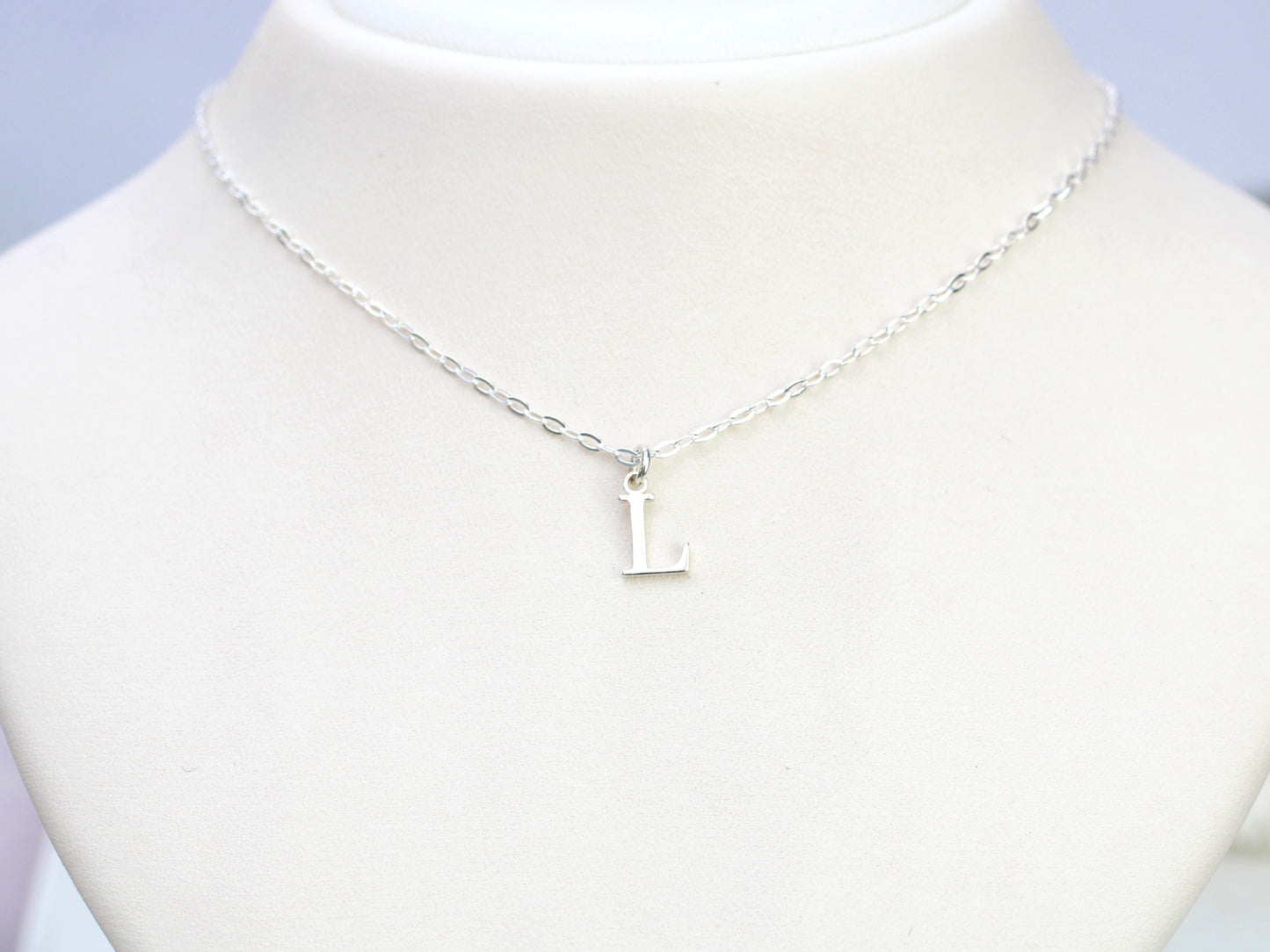 Silver initial necklace.