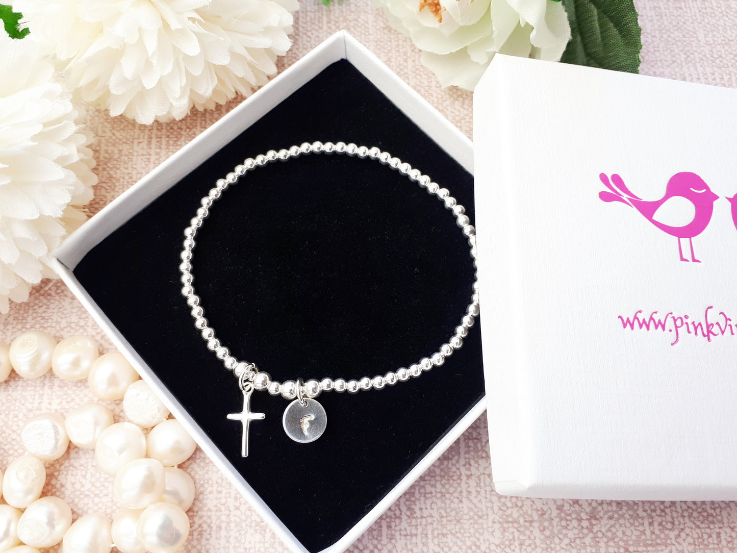 Cross charm bracelet with initial.