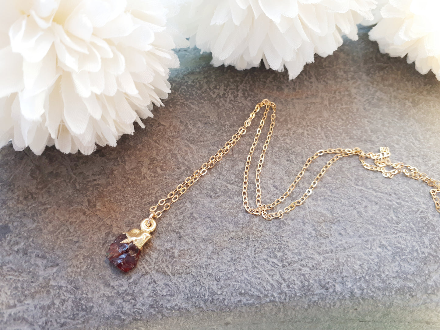 Raw garnet necklace in gold.
