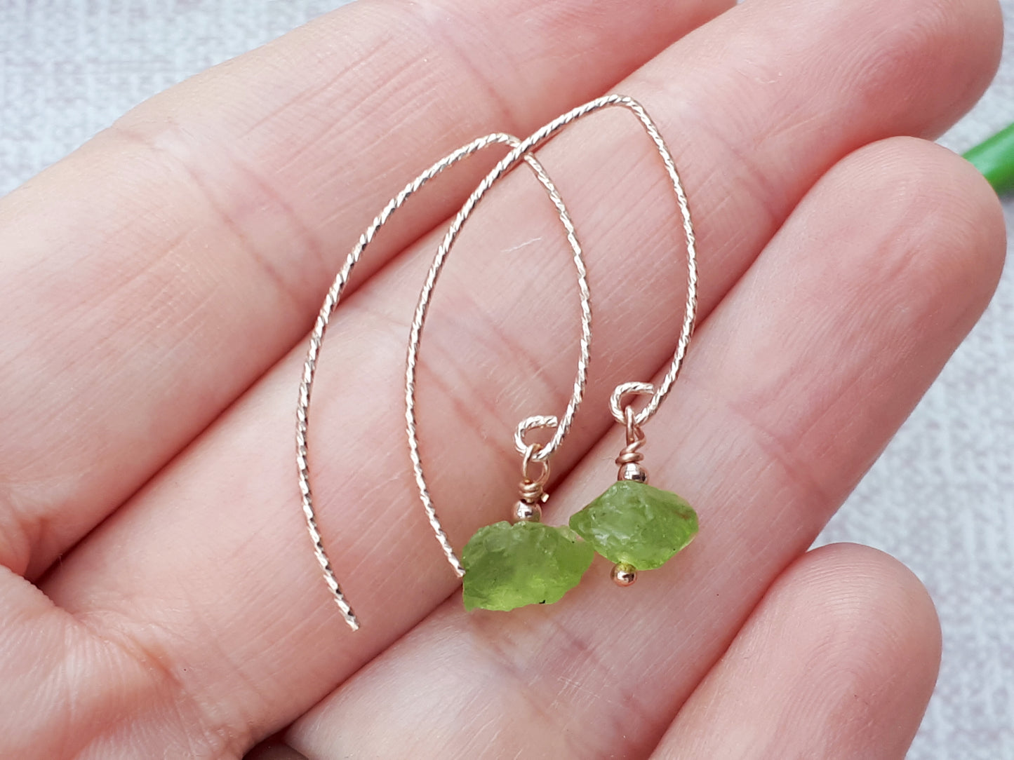 Raw peridot earrings in gold.