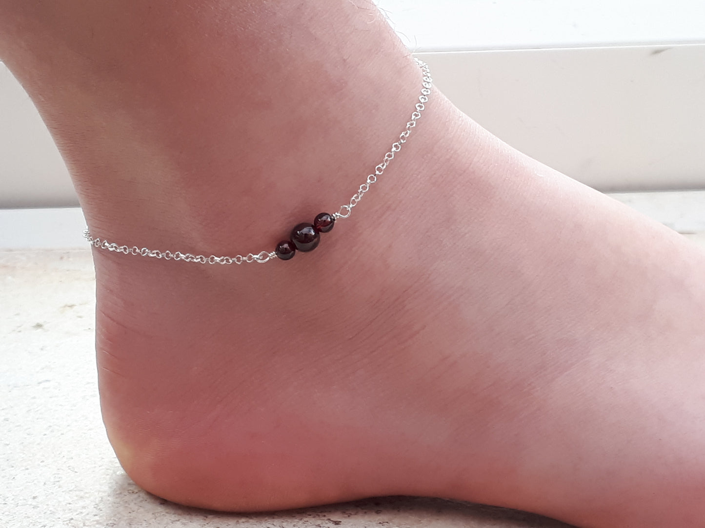 Garnet ankle bracelet in sterling silver.