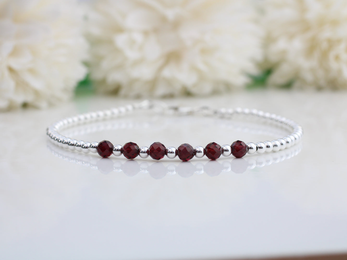 Garnet milestone bracelet in sterling silver.