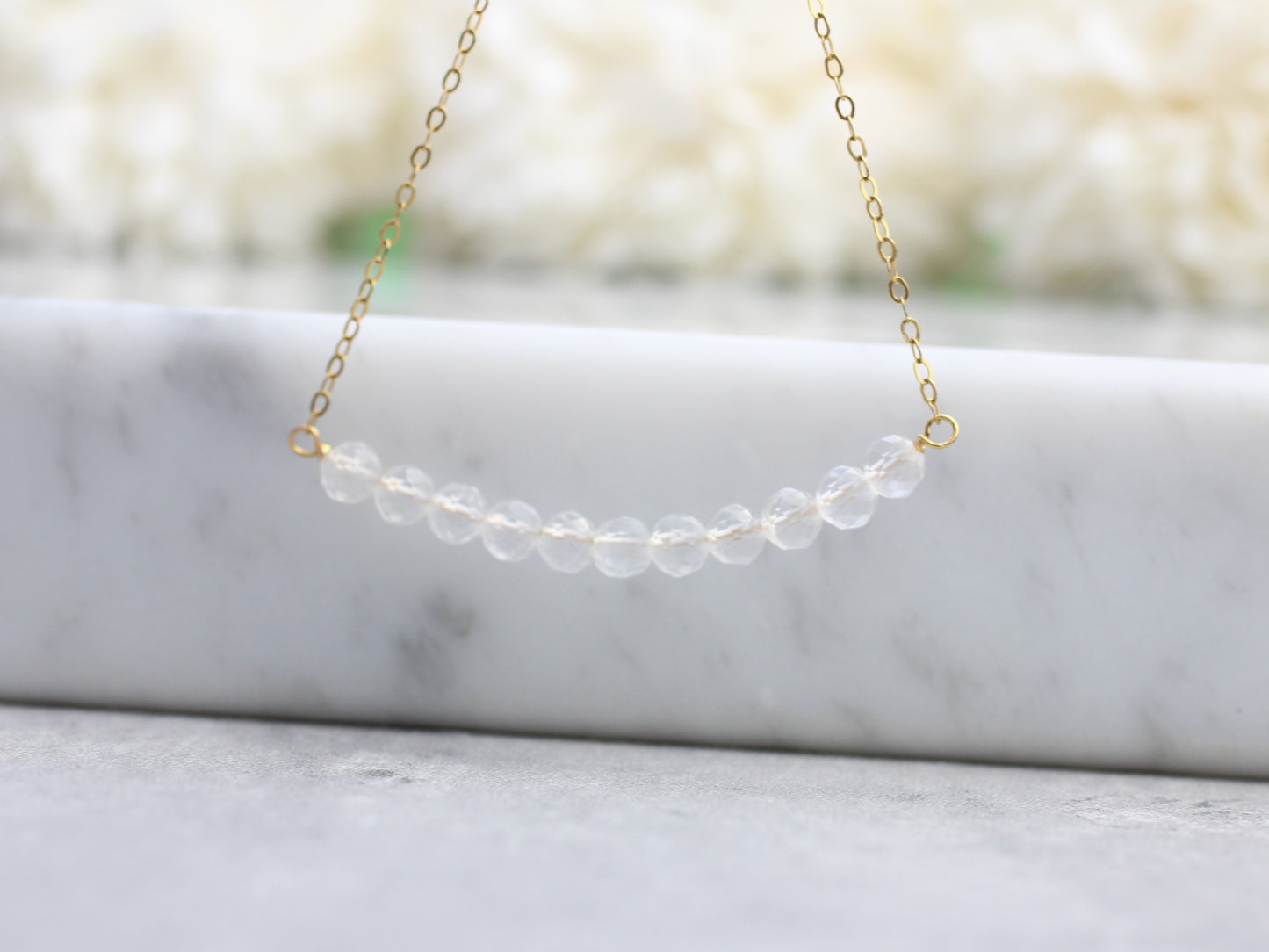 Quartz gemstone necklace in silver or gold.