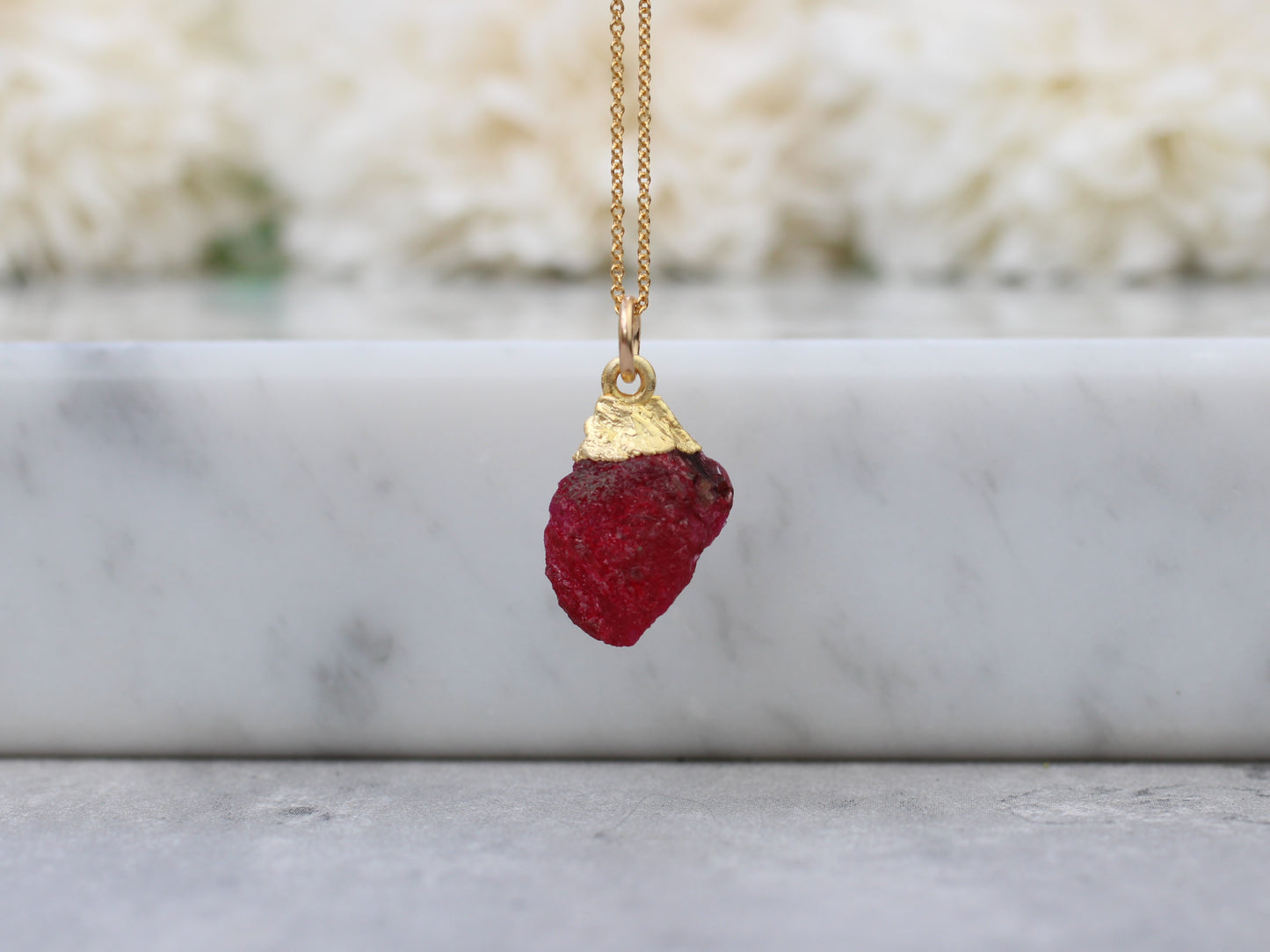 Raw ruby necklace in gold.