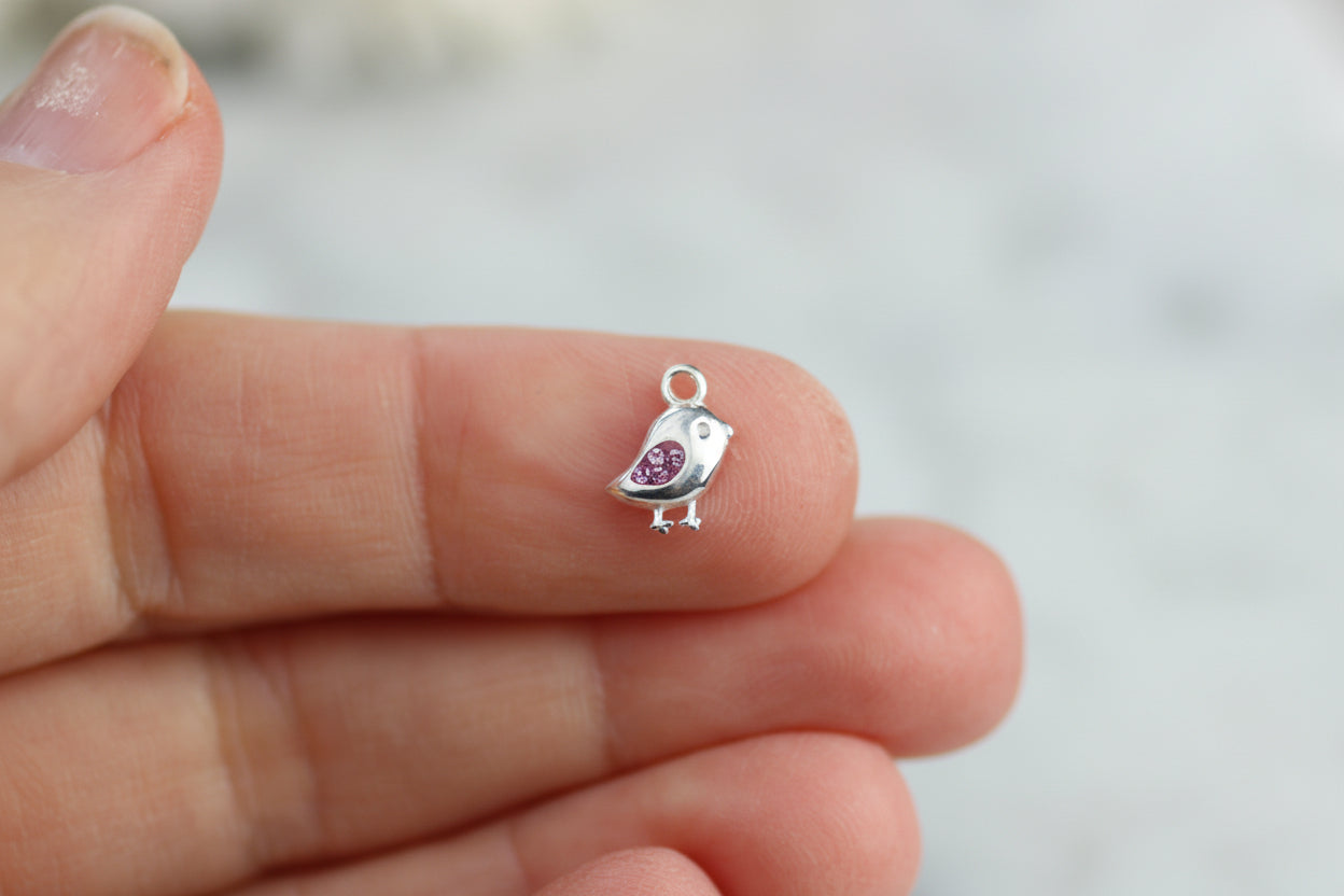 Bird charm with pink crystals.