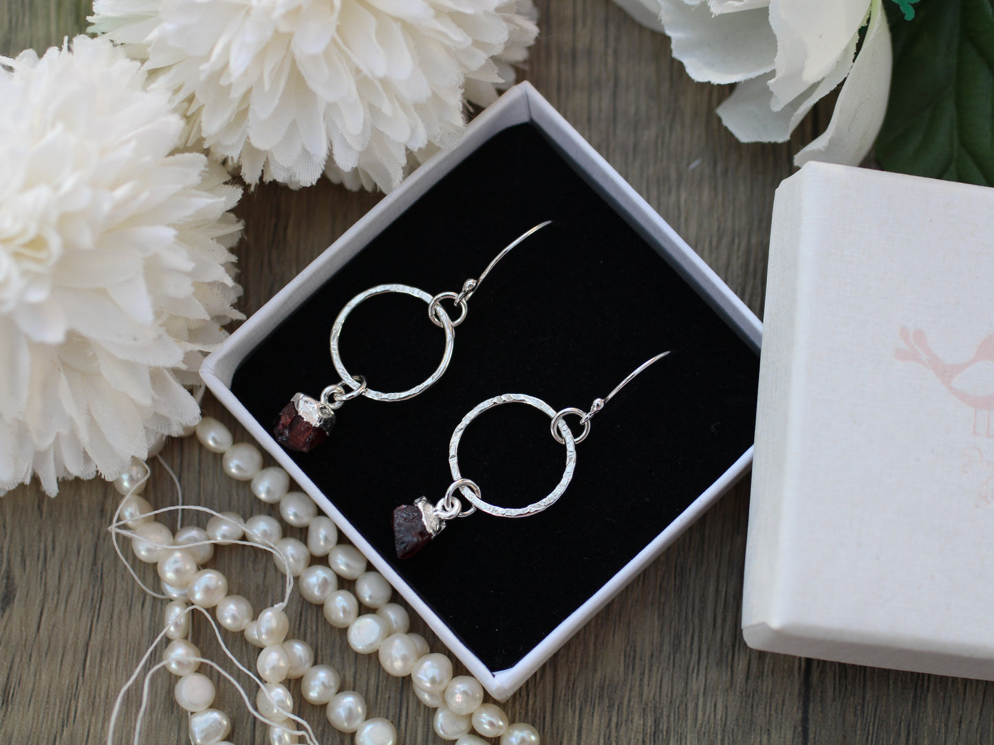 Sterling silver hoop earrings with raw garnet gemstone.