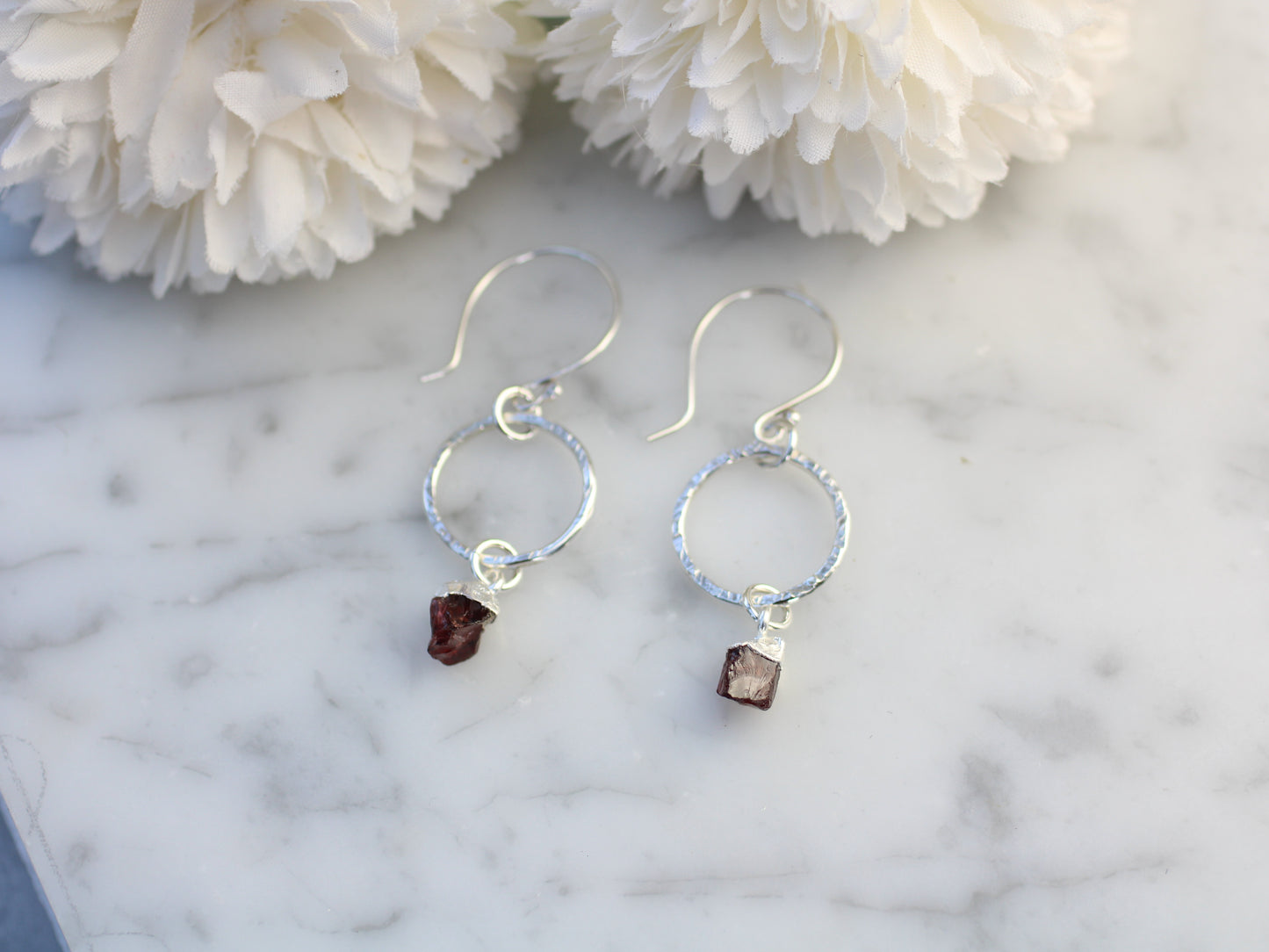 Sterling silver hoop earrings with raw garnet gemstone.
