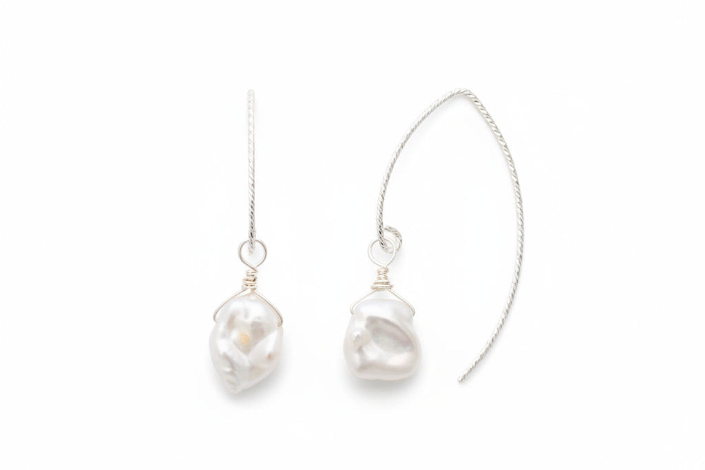 Pearl earrings on a marble surface