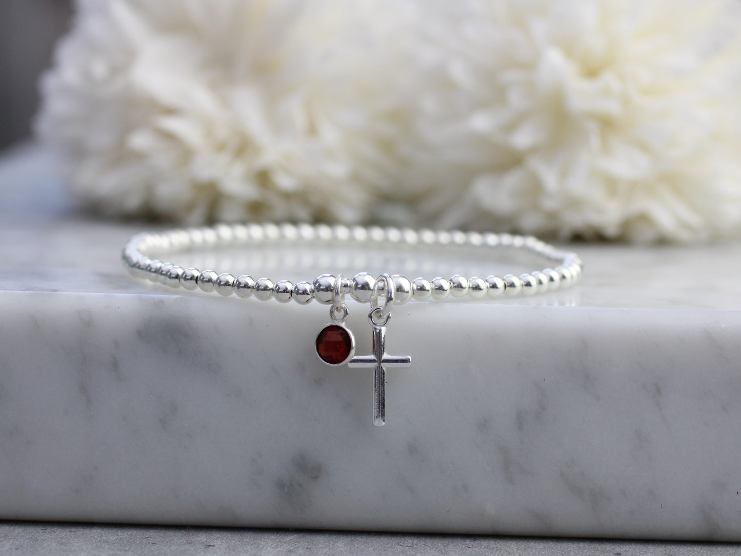 Garnet charm and cross bracelet.