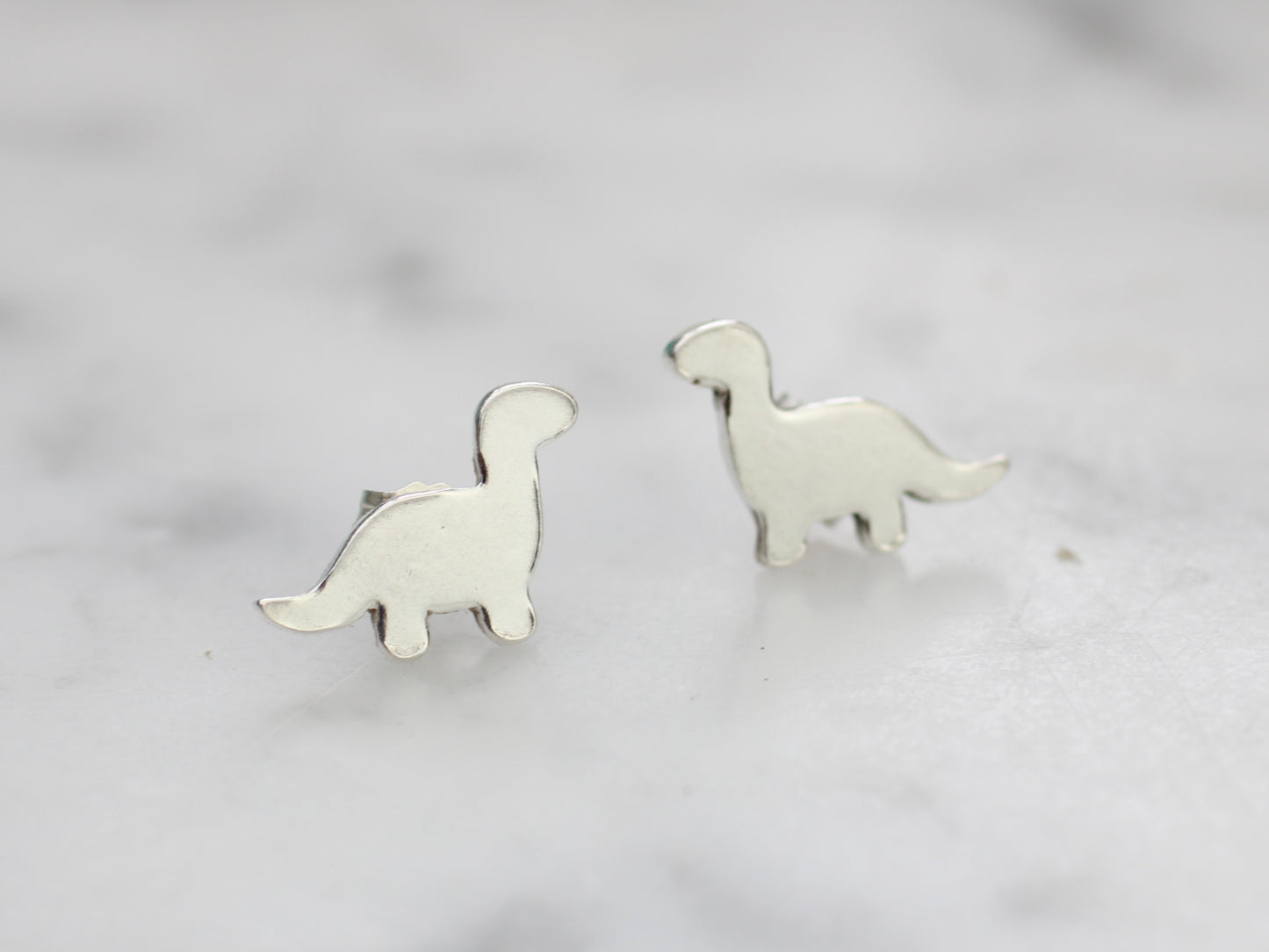 Diplodocus dinosaur stud earrings in silver.