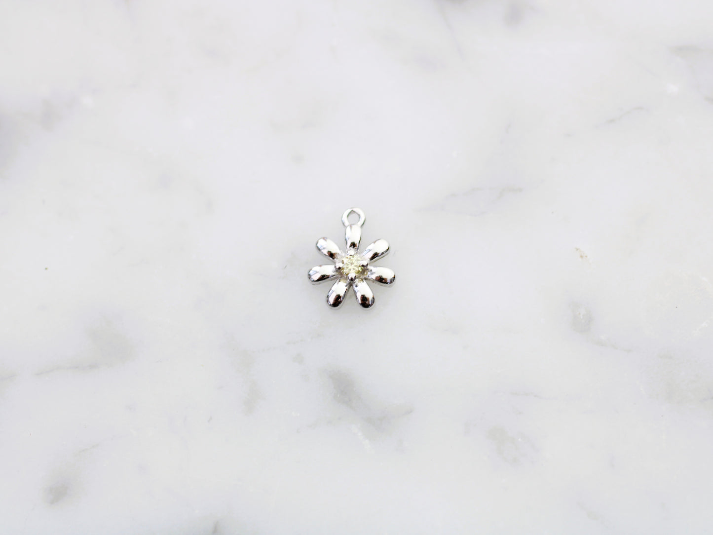 Flower charm with yellow crystal.