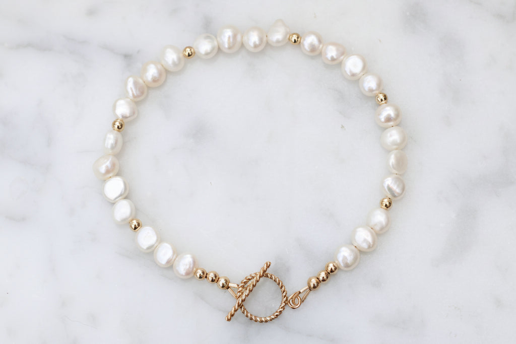 Pearl bracelet with gold clasp.
