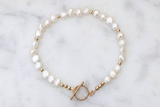 Pearl bracelet with gold clasp.