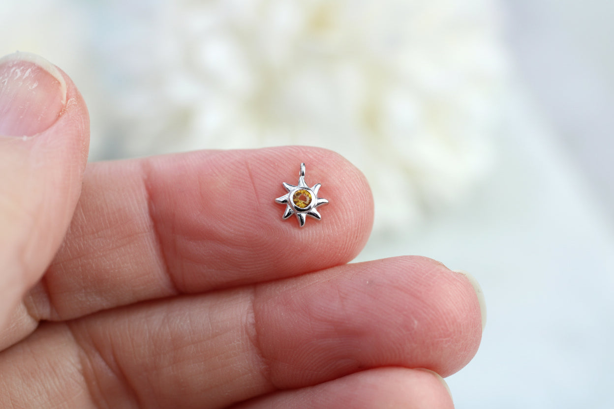 Sun charm with yellow crystal.