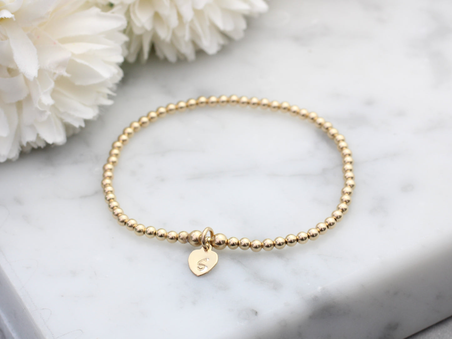 Gold initial bracelet.