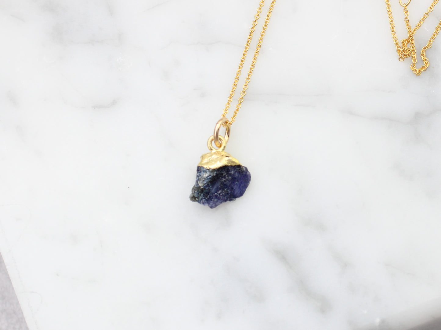 Raw sapphire necklace in gold.