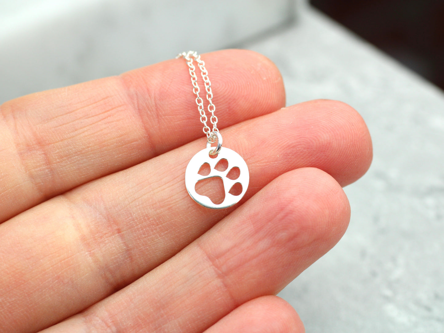 Silver paw print necklace.
