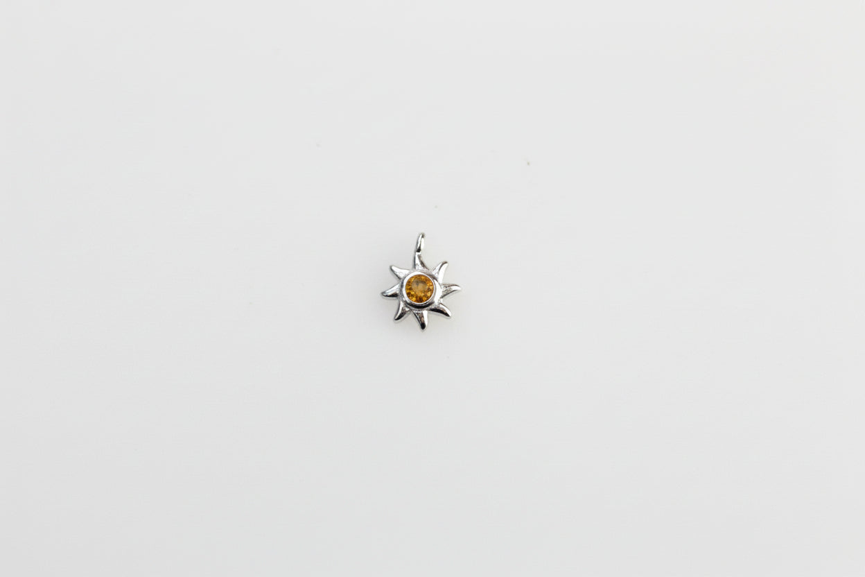 Sun charm with yellow crystal.