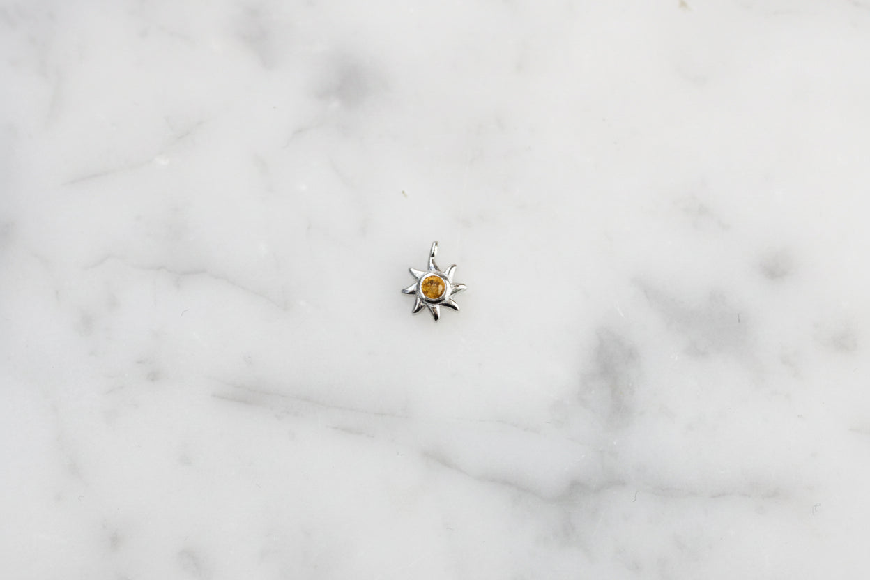 Sun charm with yellow crystal.