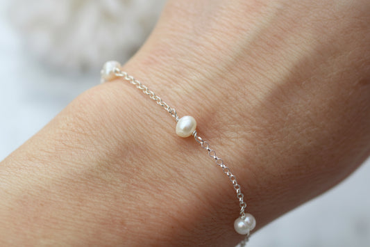 Pearl bracelet on a wrist with a blurred background