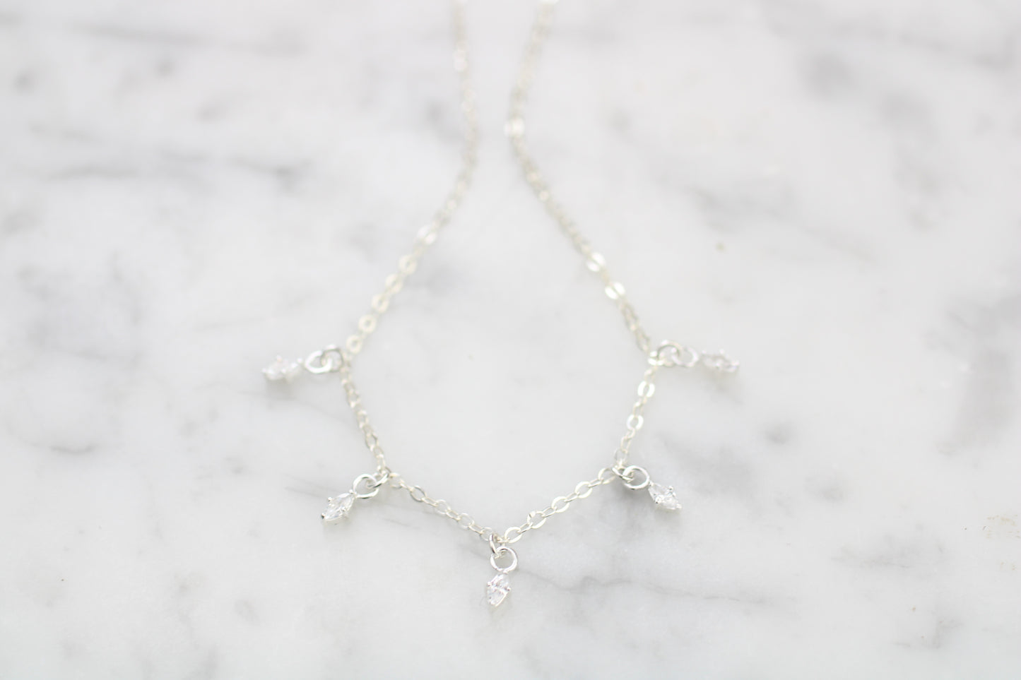 Silver necklace on a marble surface