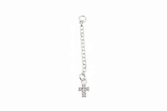 Silver chain with a small cross on a marble surface