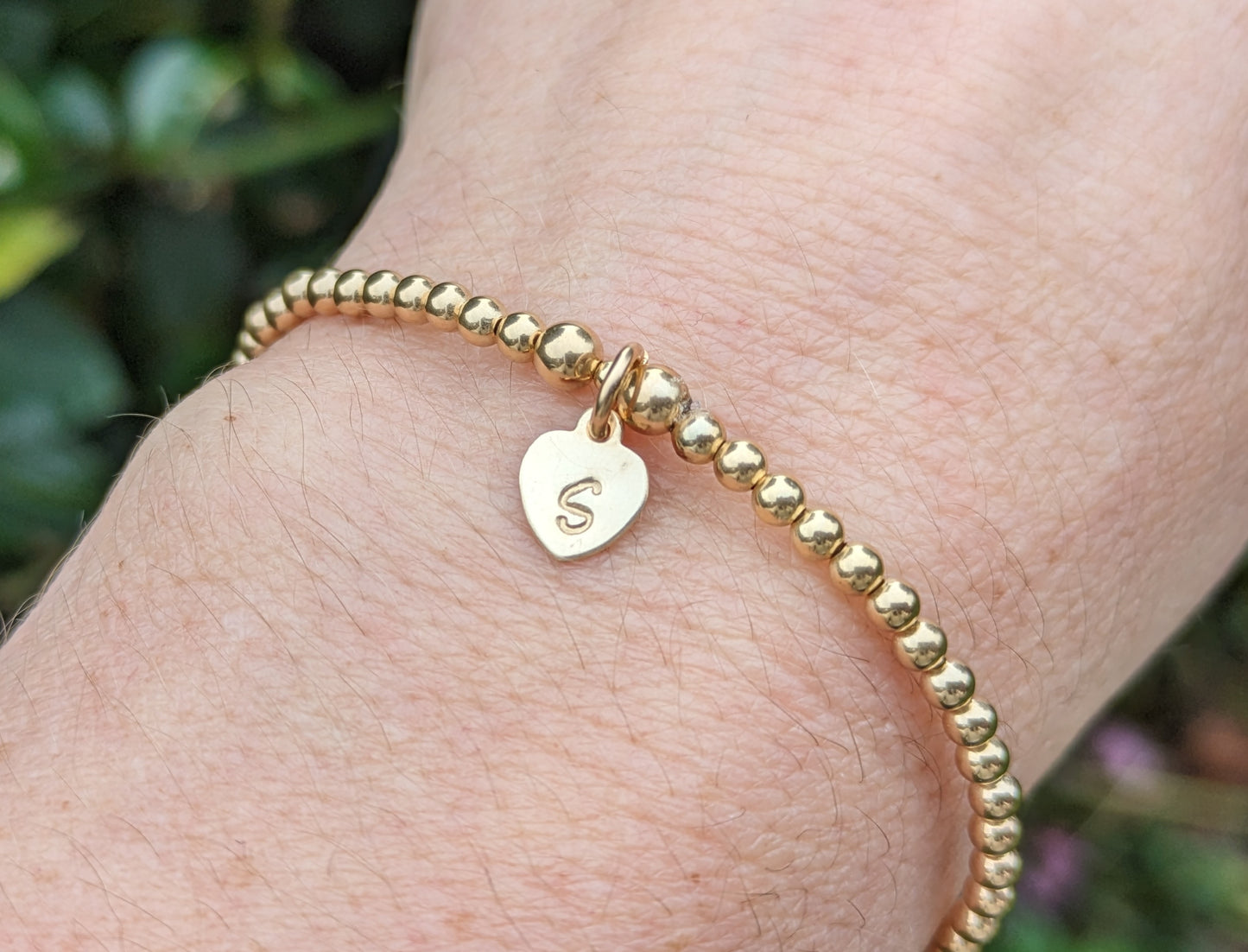 Gold initial bracelet.