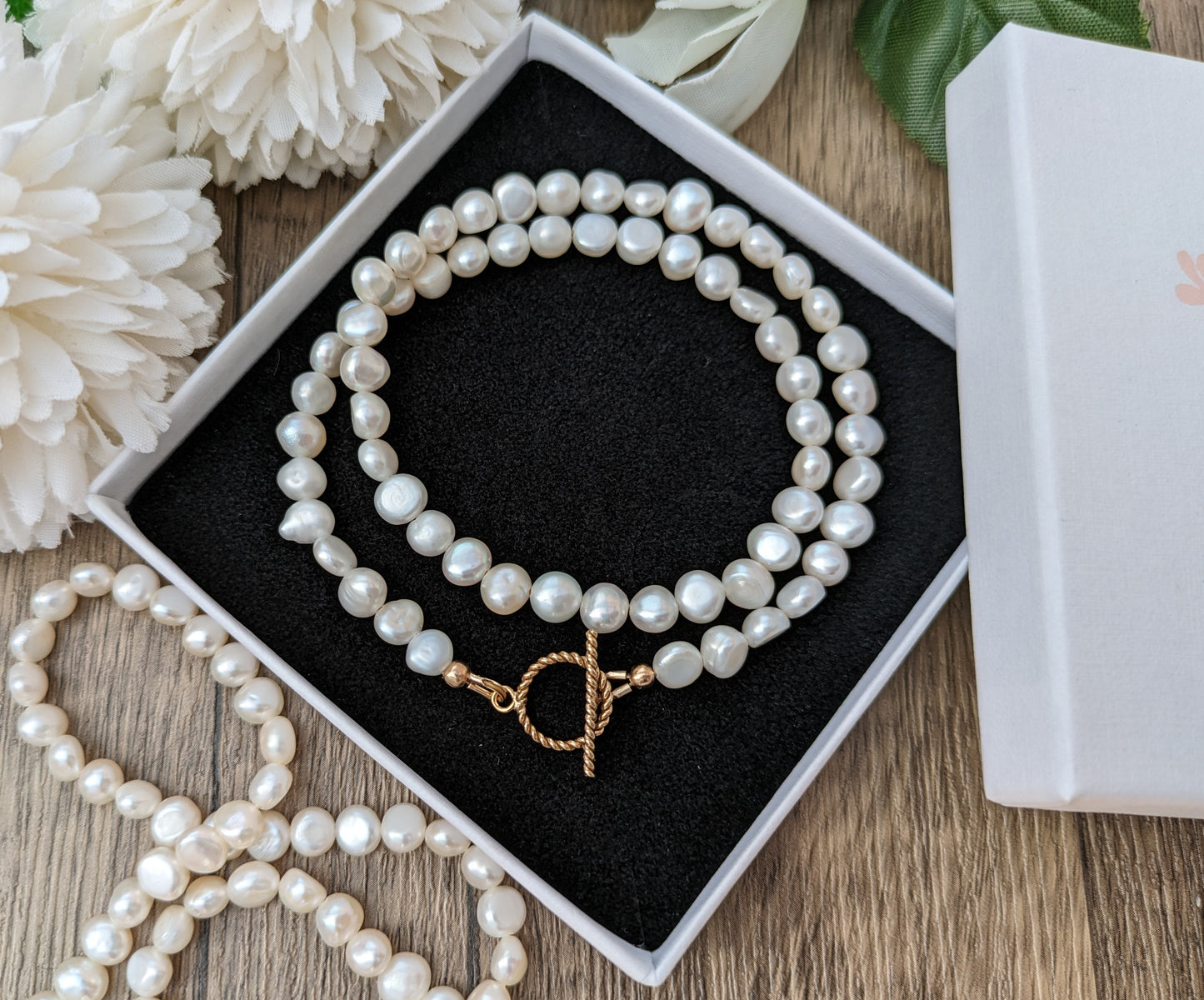 Pearl choker necklace with gold clasp.