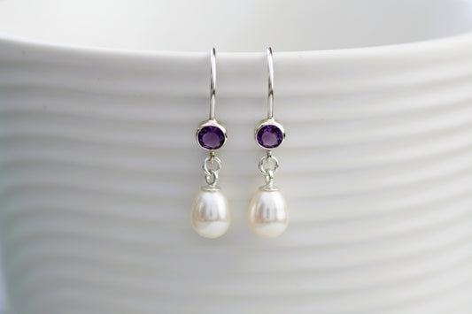 Pearl and amethyst earrings on a white background