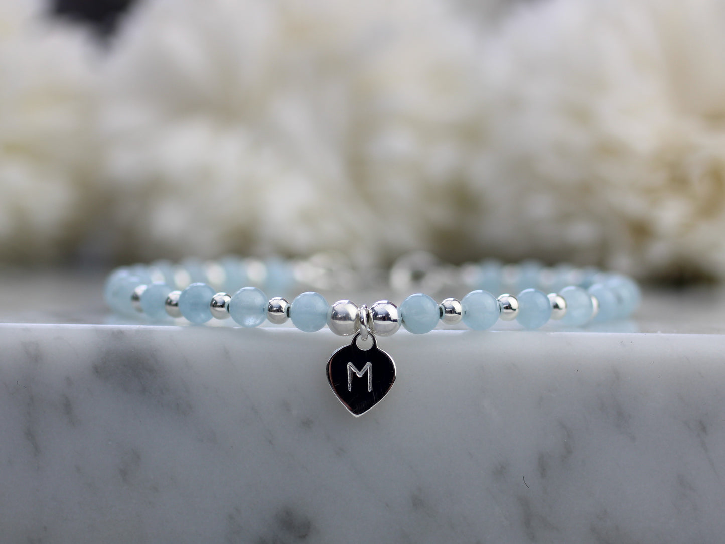 blue and silver bead bracelet with an initial tag