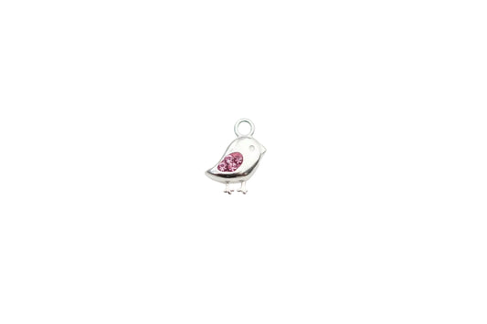 Silver bird-shaped charm with a pink crystals on a white surface