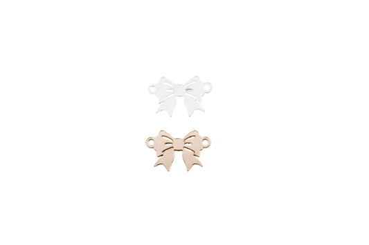 Two metallic bow-shaped objects, one gold and one silver, on a light gray background.