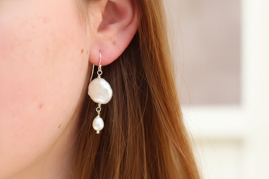Pearl earring worn by a person with blurred background